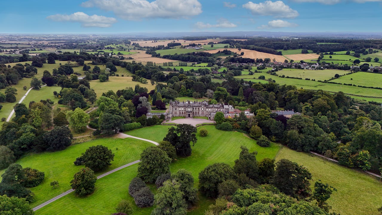 hero-img-01 Aerial photography of Sandon Estate in England showcasing its expansive green landscapes.
